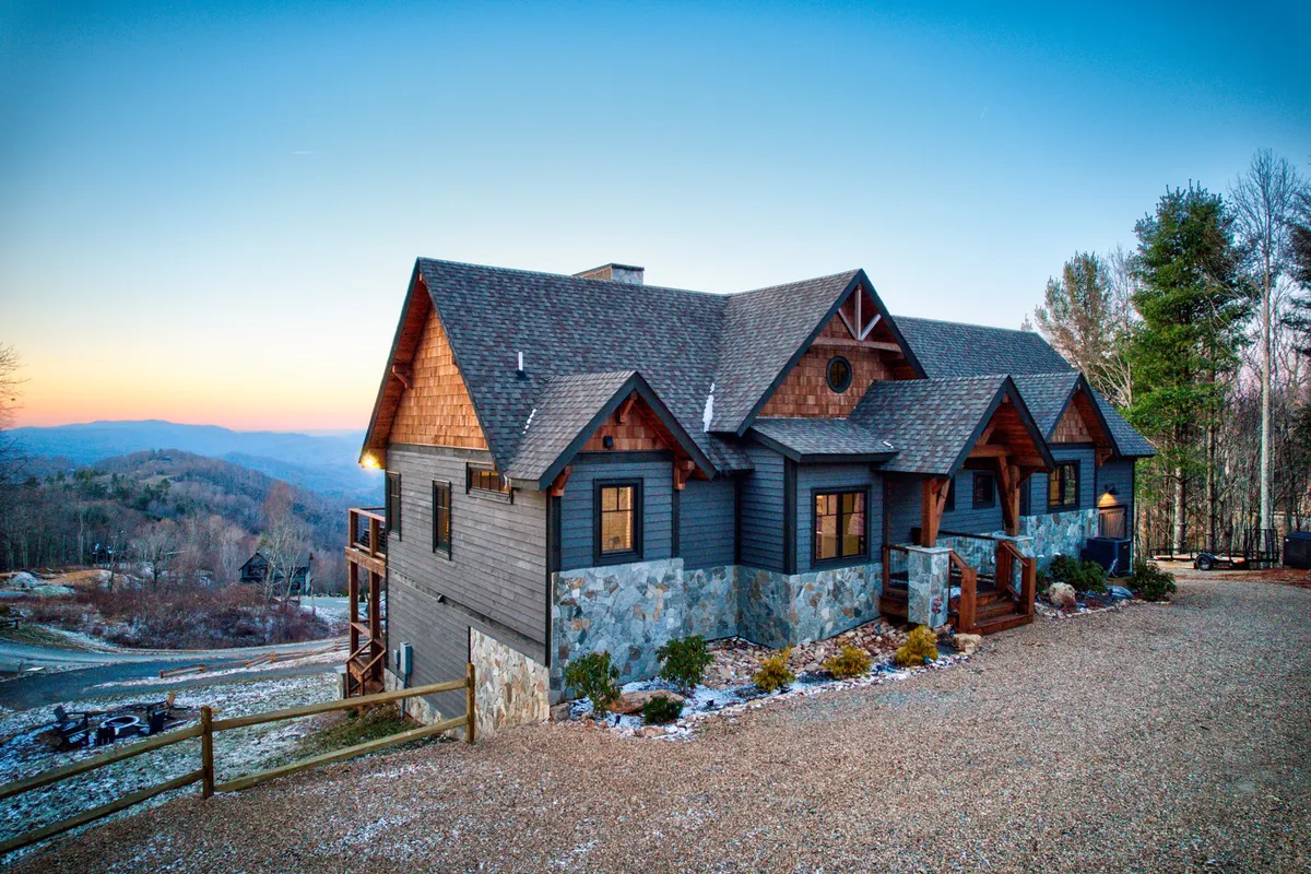 A welcoming exterior shot of a cabin at Eagles Nest, surrounded by serene landscaping and featuring a clear view of the gravel driveway—subtly referencing the mention of security and privacy. The inviting porch evokes the spirit of gathering and relaxation.